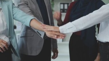 Bir grup iş adamı başarılı bir anlaşmadan sonra ellerini birleştiriyor, takım çalışması konsepti..