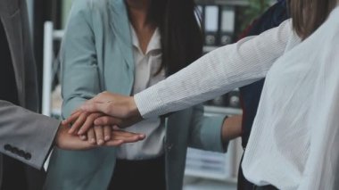 Bir grup iş adamı başarılı bir anlaşmadan sonra ellerini birleştiriyor, takım çalışması konsepti..