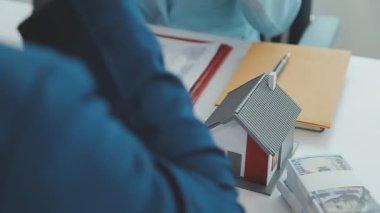 Emlakçı ve müşteri yeni bir ev, sigorta ve emlak konsepti satın alma sürecini tartışıyor
