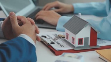 Emlakçı ve müşteri yeni bir ev, sigorta ve emlak konsepti satın alma sürecini tartışıyor