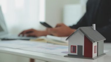 İş adamlarının hesap makinesiyle, laptopla ve ofis modeliyle başarılı iş konsepti.