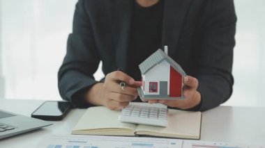 İş adamlarının hesap makinesiyle, laptopla ve ofis modeliyle başarılı iş konsepti.