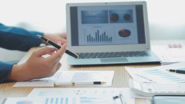 Genç iş uzmanlarından oluşan canlı bir ekip, son teknoloji ürünü bir ofiste etkili bir şekilde iş birliği yaparak finansal stratejiler ve ilkeler sergiliyor.