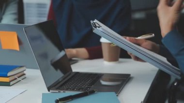 Bir grup genç girişimci çağdaş bir ofiste belgeleri gözden geçirir