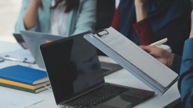 Bir grup genç girişimci çağdaş bir ofiste belgeleri gözden geçirir