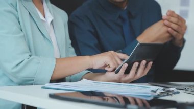 Bir grup genç girişimci çağdaş bir ofiste belgeleri gözden geçirir