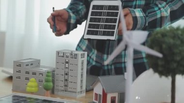 Ofiste çalışan mühendis, güneş panelleri ile inşaat tasarım projesine yakın plan