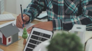 Ofiste çalışan mühendis, güneş panelleri ile inşaat tasarım projesine yakın plan