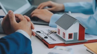 Emlakçı ve müşteri yeni bir ev, sigorta ve emlak konsepti satın alma sürecini tartışıyor