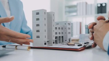 Emlakçı ve müşteri yeni bir ev, sigorta ve emlak konsepti satın alma sürecini tartışıyor