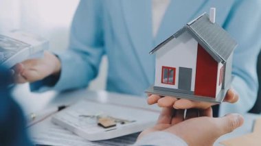 Emlakçı ve müşteri yeni bir ev, sigorta ve emlak konsepti satın alma sürecini tartışıyor