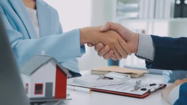 Emlakçı ve müşteri yeni bir ev, sigorta ve emlak konsepti satın alma sürecini tartışıyor