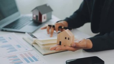 İş adamı konsepti hesap makinesinde çalışıyor, bilgisayarında ev modeli var..