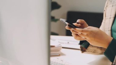 Genç bir iş kadını, iş ve finans kavramlarını ön plana çıkaran bir fon ile çağdaş bir ofiste çalışırken resmedilir..