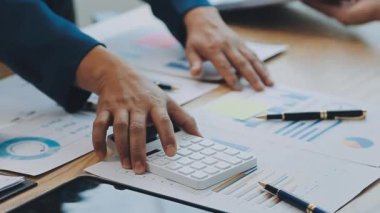 Finansal prensipleri temsil eden, modern bir ofis alanında sinerjide çalışan enerjik genç iş adamlarından oluşan bir grup