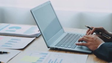 İş adamları yeni projeyi modern ofiste dizüstü bilgisayar ve iş belgeleriyle tartışıyor.