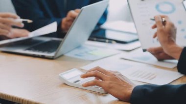 İş adamları yeni projeyi modern ofiste dizüstü bilgisayar ve iş belgeleriyle tartışıyor.