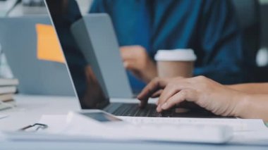 Finansal prensipleri temsil eden, modern bir ofis alanında sinerjide çalışan enerjik genç iş adamlarından oluşan bir grup