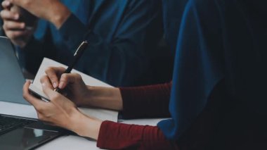 Finansal prensipleri temsil eden, modern bir ofis alanında sinerjide çalışan enerjik genç iş adamlarından oluşan bir grup