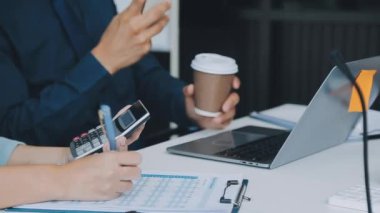 Finansal prensipleri temsil eden, modern bir ofis alanında sinerjide çalışan enerjik genç iş adamlarından oluşan bir grup