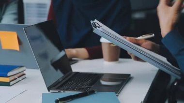 Finansal prensipleri temsil eden, modern bir ofis alanında sinerjide çalışan enerjik genç iş adamlarından oluşan bir grup