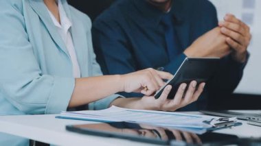 Finansal prensipleri temsil eden, modern bir ofis alanında sinerjide çalışan enerjik genç iş adamlarından oluşan bir grup