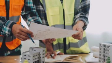 İnşaat mühendisi planlar ve planlar üzerinde çalışıyor.