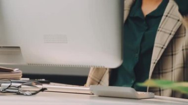 Tasarımcı ofisinde bir bilgisayar üzerinde çalışıyor..