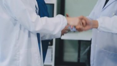Modern bir ofiste doktorların ve diğer tıbbi ekibin el sıkışması..