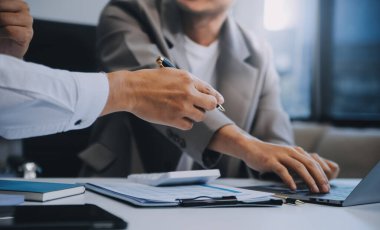 İş ekibi ile yeni başlangıç planı ve tartışma için proje bilgilerini dizüstü bilgisayar ve dijital tablet ile mali strateji bir modern iş salonda çalışıyor.