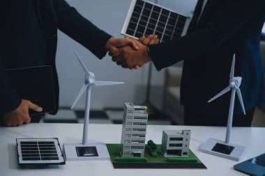İki Genç Mühendis Güneş Hücresi Kurulum Toplantısı ve İş Tartışması Uzmanı. Ofis Odası 'nda Fabrika İnşaat Planlı Çatı Üzerine Güneş Fotovoltaik Panelleri Kurmayı Planlıyorum.