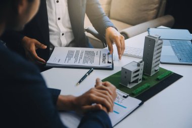 Emlakçı ev satın alma anlaşmasının şartları hakkında konuştu ve müşteriden sözleşmeyi yasal hale getirmek için belgeleri imzalamasını istedi, ev satışları ve ev sigortası kavramı.