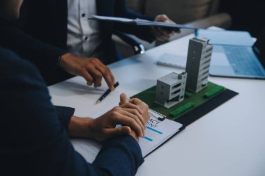 Emlakçı ev satın alma anlaşmasının şartları hakkında konuştu ve müşteriden sözleşmeyi yasal hale getirmek için belgeleri imzalamasını istedi, ev satışları ve ev sigortası kavramı.