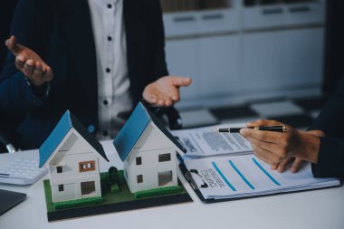 Emlakçı ev satın alma anlaşmasının şartları hakkında konuştu ve müşteriden sözleşmeyi yasal hale getirmek için belgeleri imzalamasını istedi, ev satışları ve ev sigortası kavramı.