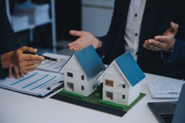 Emlakçı ev satın alma anlaşmasının şartları hakkında konuştu ve müşteriden sözleşmeyi yasal hale getirmek için belgeleri imzalamasını istedi, ev satışları ve ev sigortası kavramı.