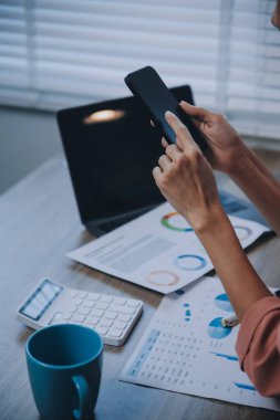 Kapalı alanda cep telefonu kullanan mutlu bir Asyalı iş kadınının portresi. Modern ofiste çalışan Asyalı bir iş kadını..