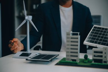 İki Genç Mühendis Güneş Hücresi Kurulum Toplantısı ve İş Tartışması Uzmanı. Ofis Odası 'nda Fabrika İnşaat Planlı Çatı Üzerine Güneş Fotovoltaik Panelleri Kurmayı Planlıyorum.