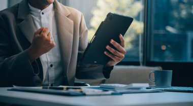 Ofis, tablet ve işadamı olumlu mali tasarruflar, finans bütçesi raporu veya idari geri bildirimden memnun. Büyüme analizleri, veri analizi ve araştırma istatistikleri için gülümseme
