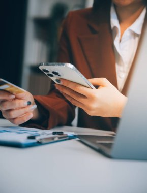 Elleri plastik kredi kartı tutuyor ve dizüstü bilgisayar kullanıyor. İnternetten alışveriş konsepti. Renkli resim
