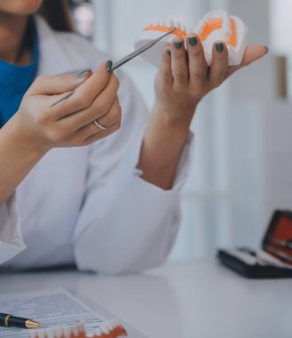 Diş hekimleri dişlerle ilgili problem rapor x-ray görüntü dizüstü bilgisayar ekranında hastalara görüşüyorlar.