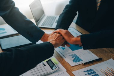 İş adamları, takım çalışması olarak güçlerini birleştirmek için el ele verdiler..