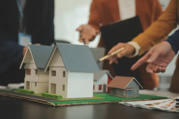 Mimarlar ve iş adamları, emlak yatırımları ve konut geliştirme projesi için zemin planı modifikasyonunu tartışıp fikir alışverişinde bulunuyorlar.