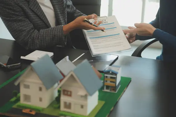 Mimarlar ve iş adamları, emlak yatırımları ve konut geliştirme projesi için zemin planı modifikasyonunu tartışıp fikir alışverişinde bulunuyorlar.