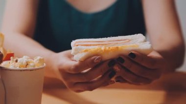  Arka planda sandviç yiyen kadın, kapat.