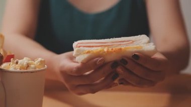 Genç Asyalı kadın elinde abur cubur, aşırı kilolu ve sağlıksız gıda konsepti tutuyor. 