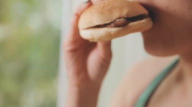 Arka planda hamburger yiyen kadınlara yakın çekim