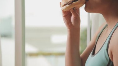 Arka planda hamburger yiyen kadınlara yakın çekim
