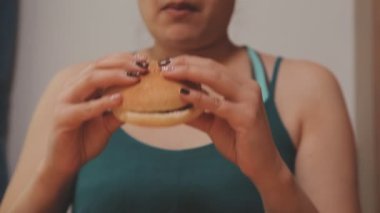 Genç Asyalı kadın elinde abur cubur, aşırı kilolu ve sağlıksız gıda konsepti tutuyor. 