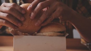 Arka planda hamburger ve abur cubur yiyen kişi, kapat.