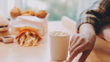 Kadın arka planda fast food yiyor.